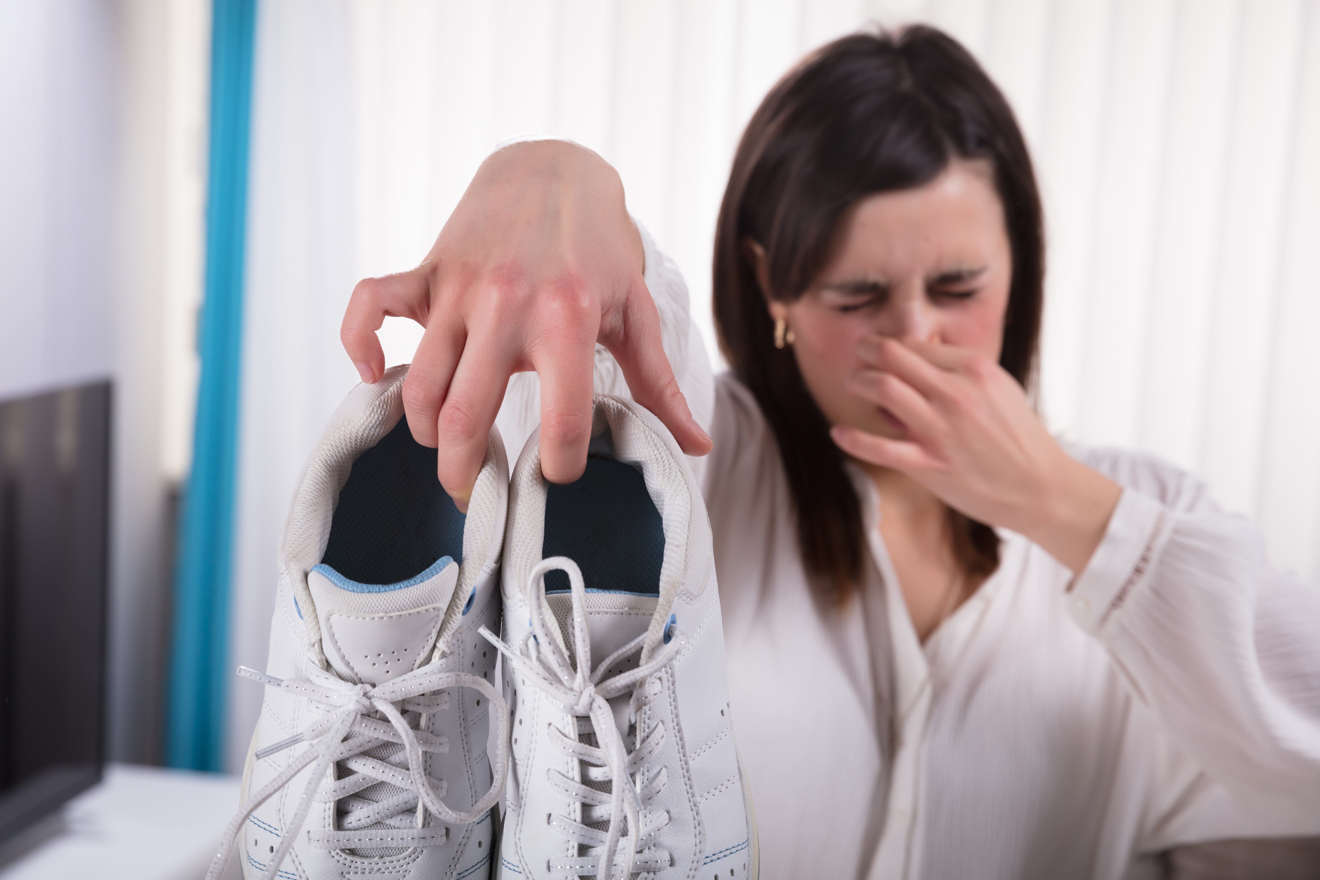 Woman Holding Dirty Smelling Shoes