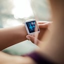 Mujer deportiva mirando su reloj inteligente