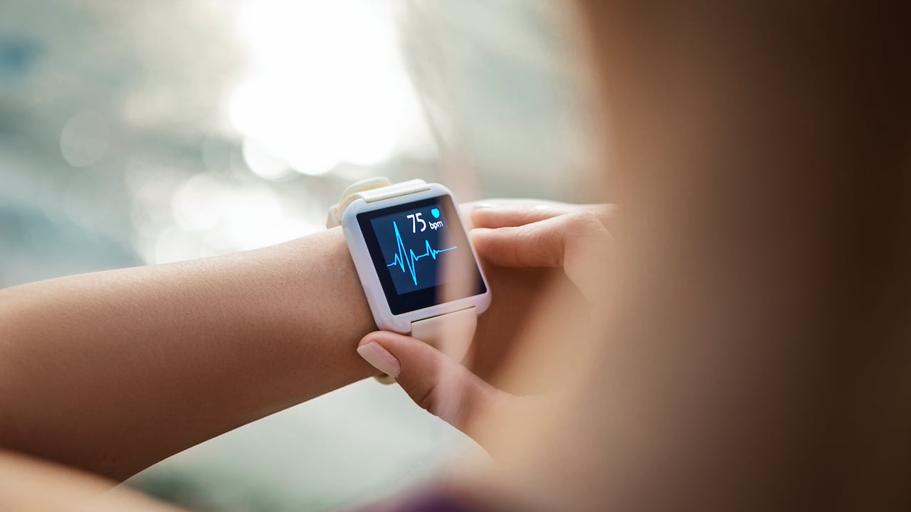 Mujer deportiva mirando su reloj inteligente