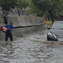 La gente intenta vaciar una calle inundada tras el paso de la tormenta tropical Hilary, que no afecta gravemente a la región a diferencia de otros lugares, en Tijuana, México, el 21 de agosto de 2023.