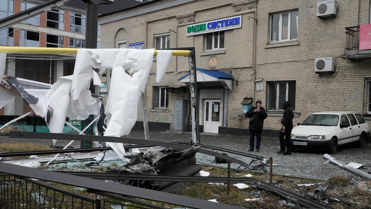 Una mujer toma una foto de las consecuencias de los bombardeos rusos en Kiev, Ucrania, el 24 de febrero del 2022.