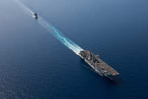 In this photo released by the U.S. Navy, the amphibious assault ship USS Bataan, front, and the landing ship USS Carter Hall, back travel through the Red Sea, Tuesday, Aug. 8, 2023. Western-backed maritime forces in the Middle East on Saturday, Aug. 12, warned shippers traveling through the strategic Strait of Hormuz to stay as far away from Iranian territorial waters as possible to avoid being seized, a stark advisory amid heightened tensions between Iran and the U.S. (Mass Communication Specialist 3rd Class Riley Gasdia/U.S. Navy, via AP)