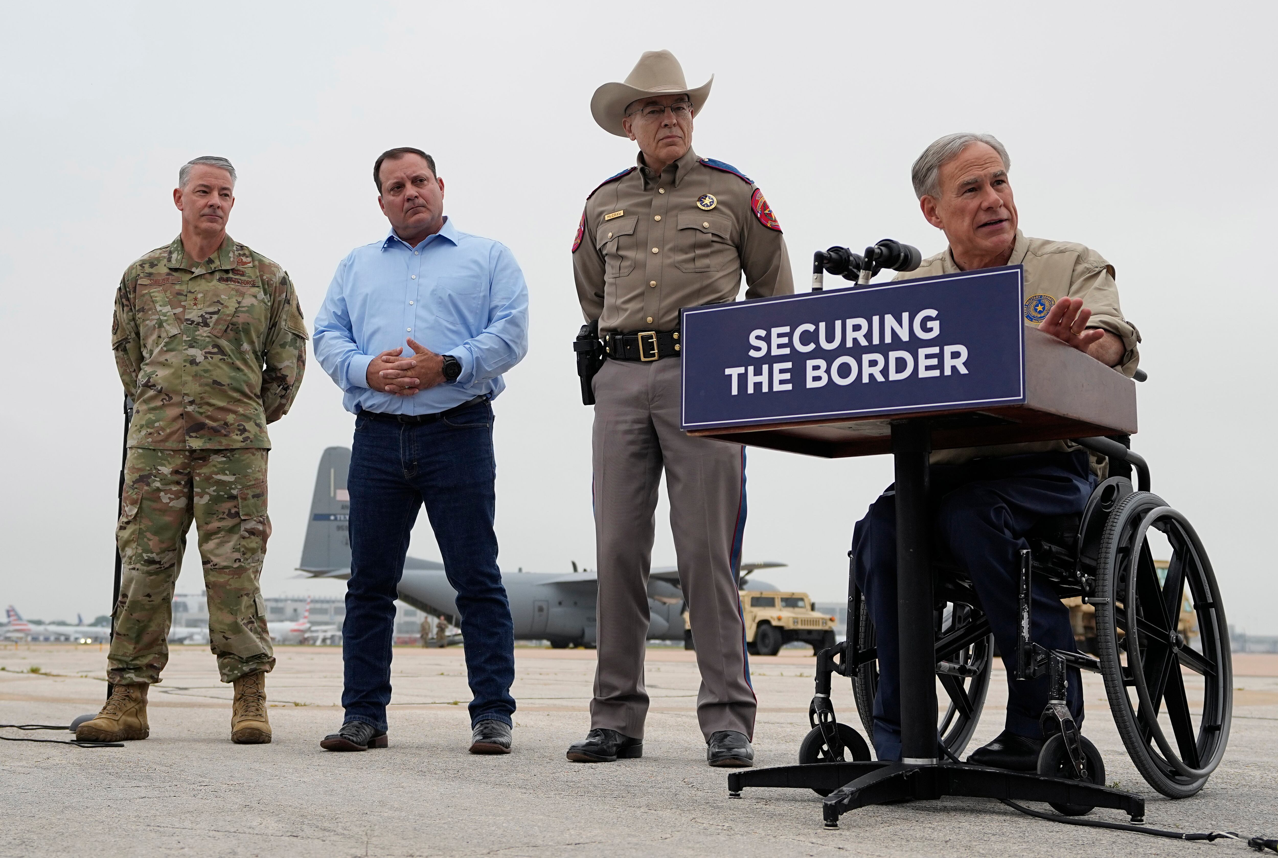 El gobernador de Texas, Greg Abbott, a la derecha, da una conferencia de prensa mientras los miembros de la Guardia Nacional de Texas se preparan para desplegarse en la frontera entre Texas y México