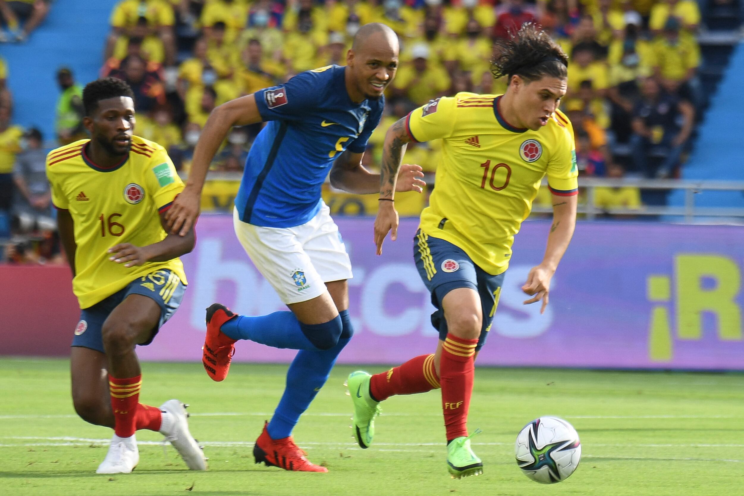 Brazil's Fabinho (C) and Colombia's Juan Fernando Quintero (R) vie for the ball during their South American qualification football match for the FIFA World Cup Qatar 2022 at the Metropolitano stadium in Barranquilla, Colombia, on October 10, 2021.
JUAN BARRETO / AFP