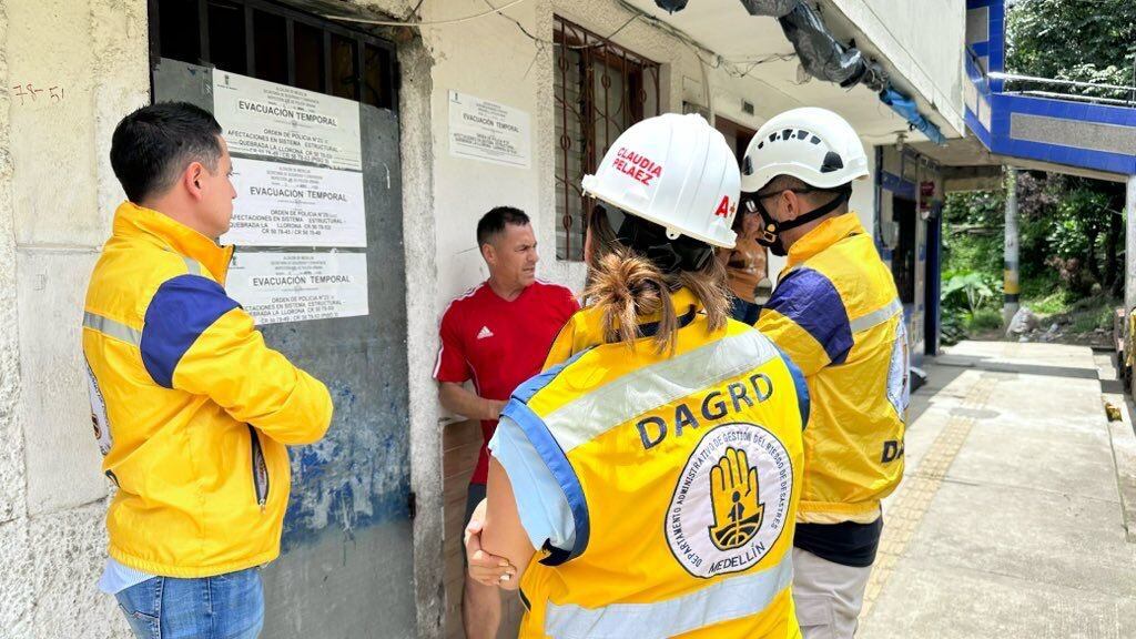 Funcionarios del Dagrd informan a habitantes de 13 viviendas en Campo Valdés, nororiente de Medellín, que deben evacuar sus casas por riesgo de colapso.
