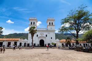 Personas no identificadas caminan por la plaza central el 3 de mayo de 2016 en Girón, Colombia.
