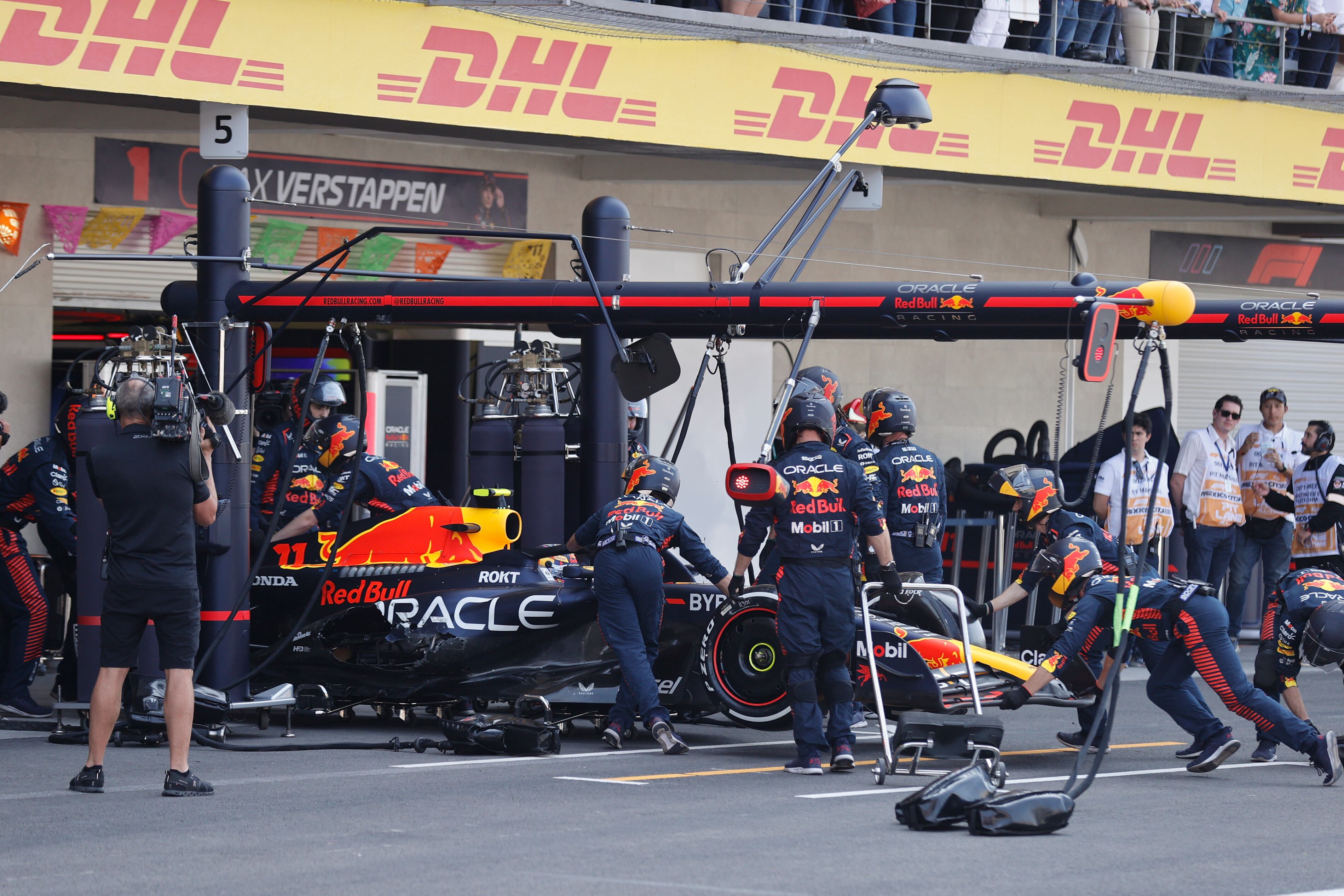 Los mecánicos de Red Bull trabajan en el auto del piloto Sergio Pérez de México después de que se estrelló durante el inicio de la carrera automovilística del Gran Premio de México de Fórmula Uno en el autódromo Hermanos Rodríguez en la Ciudad de México, el domingo 29 de octubre de 2023. (Andrés Stapff/Pool foto vía AP)