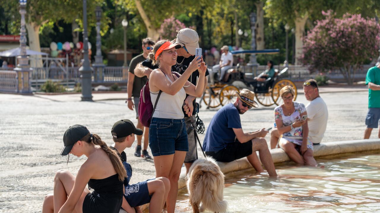 Los turistas se refrescan en la fuente de la Plaza de España, en plena ola de calor el 07 de agosto de 2023 en Sevilla (Andalucía, España). La Agencia Estatal de Meteorología (Aemet) ha activado este martes el aviso naranja por altas temperaturas, de 13.00 a 21.00 horas en Sevilla.