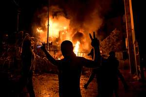 Un manifestante libanés hace el signo de la victoria frente a un edificio en llamas justo afuera de la Embajada de los Estados Unidos durante una protesta en solidaridad con el pueblo de Gaza para condenar un ataque contra un hospital en la Franja de Gaza que mató a más de 500 personas. Foto: Stringer/dpa (Foto de Stringer/picture Alliance vía Getty Images)