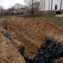 Los vecinos se reúnen junto a una fosa común en Bucha, en las afueras de Kiev, Ucrania, el domingo 3 de abril de 2022.