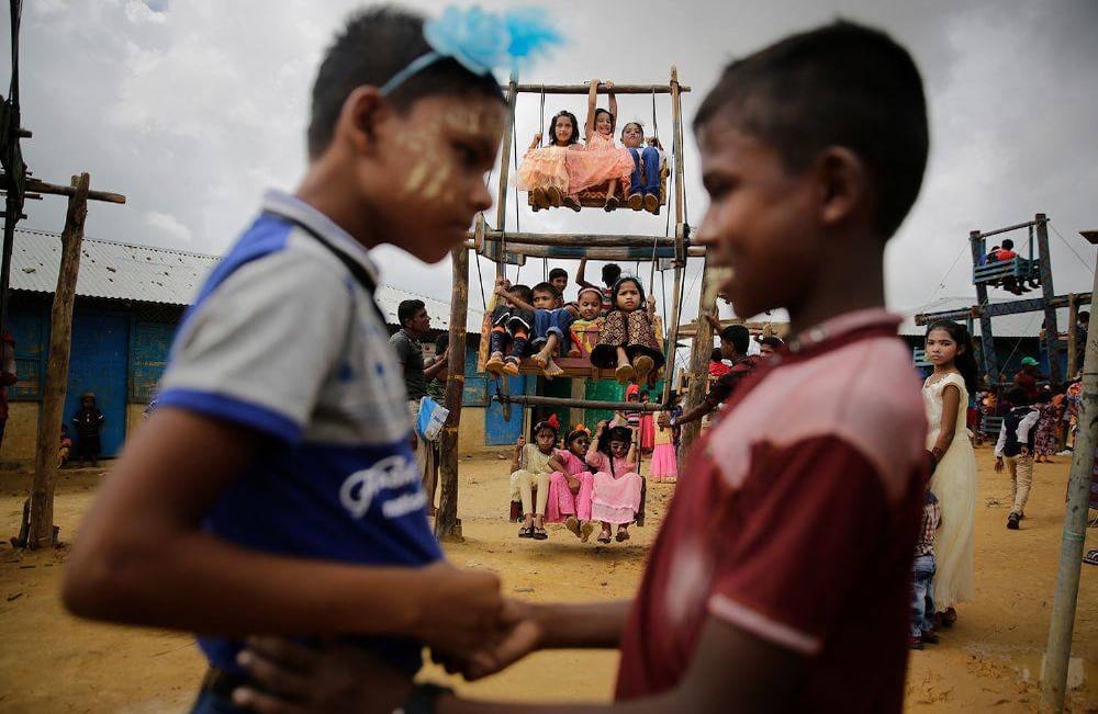 Los niños refugiados de Rohingya se saludan mientras viajan en una noria, llevados a los campamentos para las celebraciones de Eid al-Adha, en el campamento de refugiados de Kutupalong en Bangladesh, en medio de la incertidumbre sobre su futuro después de huir de Myanmar para escapar de la violencia. (Foto AP / Altaf Qadri)