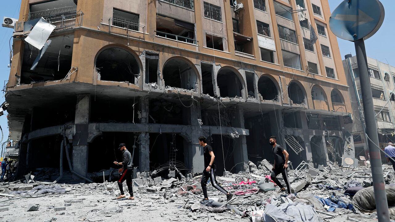La gente inspecciona los escombros de un edificio dañado que fue alcanzado por un ataque aéreo israelí, en la ciudad de Gaza, el miércoles 12 de mayo de 2021. Foto: AP / Adel Hana.