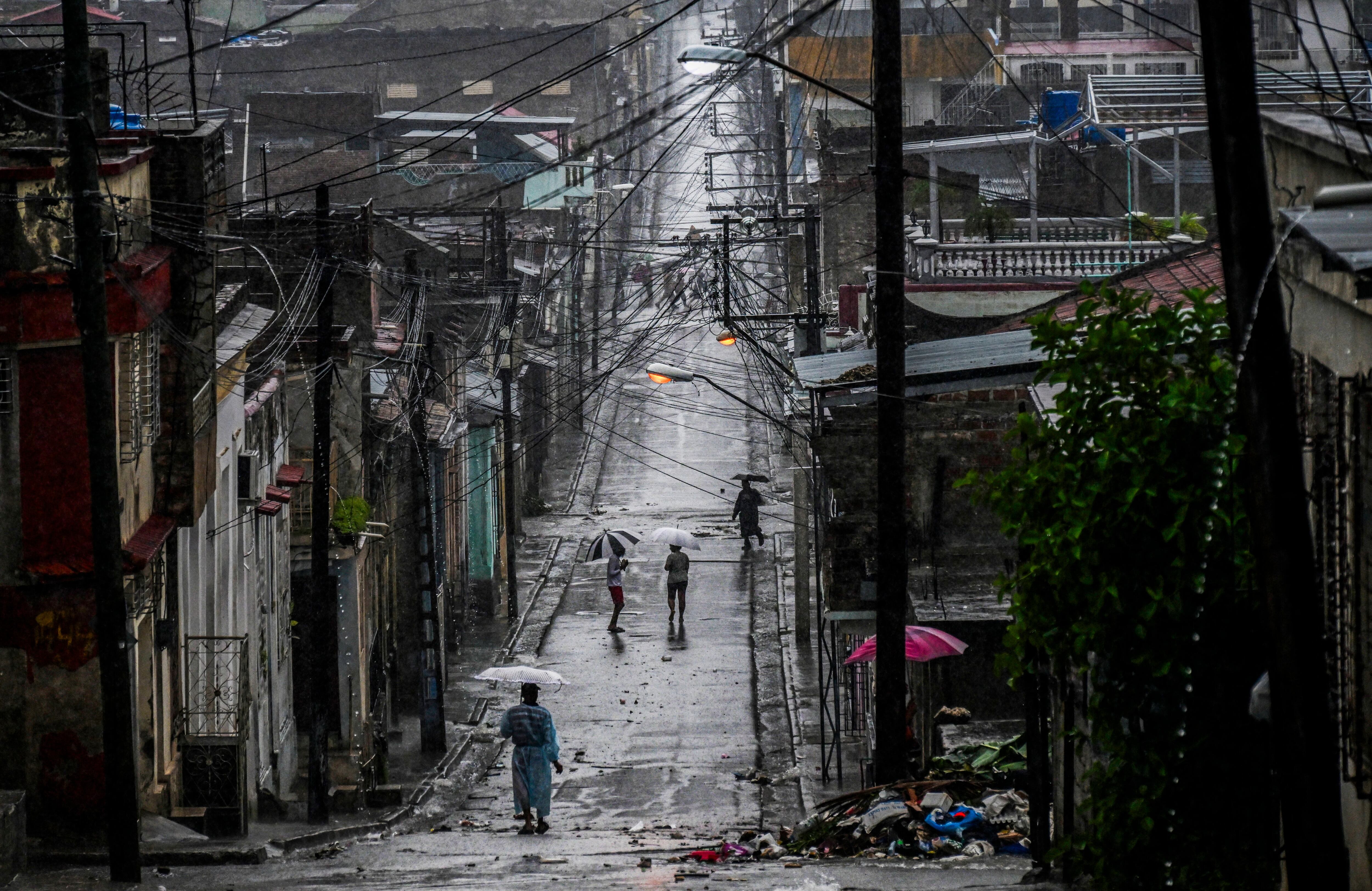 La gente camina por una calle antes de que el huracán Melissa azote la ciudad de Santiago de Cuba.