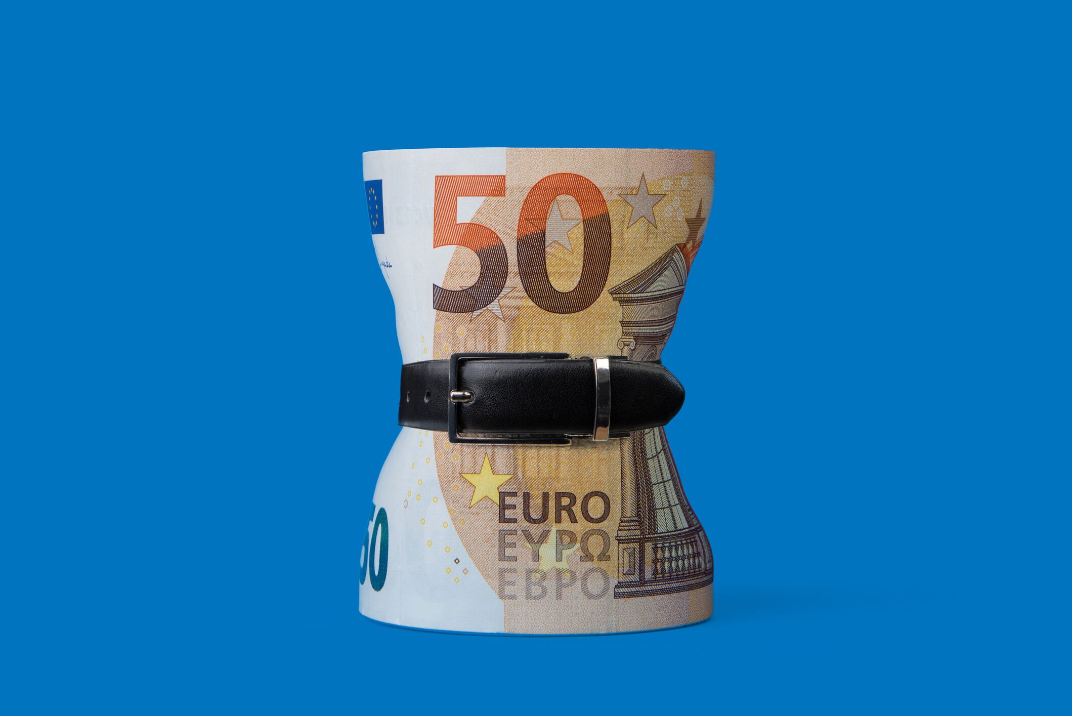 Fajo de euros atados con un cinturón apretado. Concepto de inflación