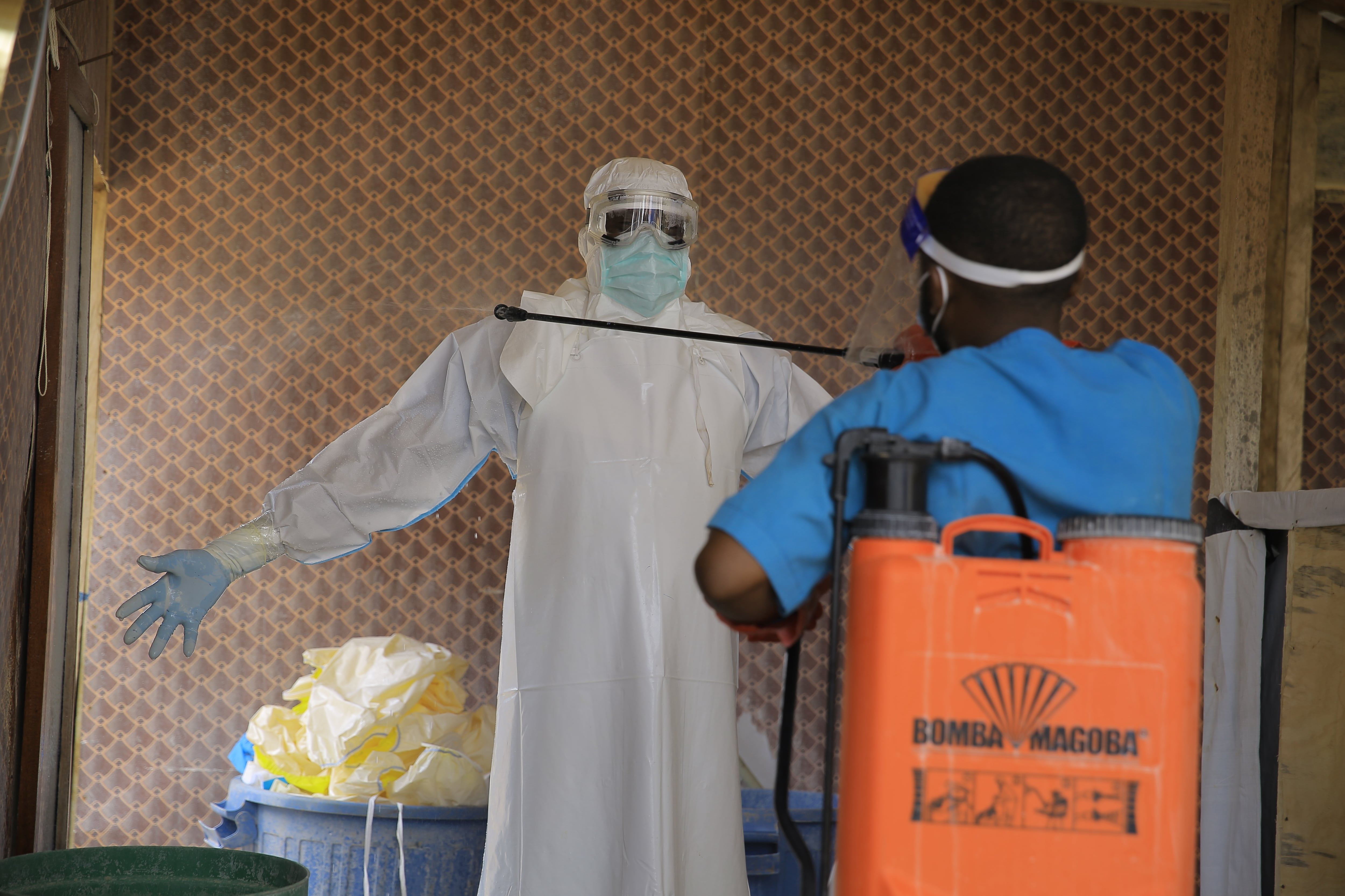 A healthcare worker is disinfected by a colleague inside a treatment center for Ebola patients in Beni, North Kivu province, eastern Congo, Tuesday, Oct. 27, 2026. (AP Photo/Sebastien Kitsa Musayi)
