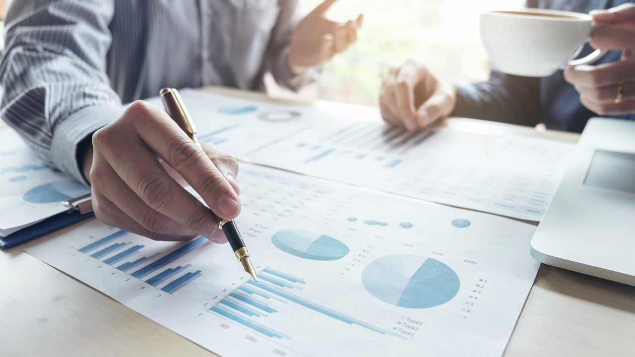 Dos hombres de negocios o contadores trabajando Inversión financiera, escribiendo informes Analizando el crecimiento del negocio y del mercado y señalando el gráfico de datos de documentos financieros, Contabilidad, Económico, comercial.