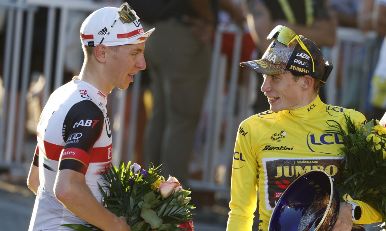 Tour de France winner Denmark's Jonas Vingegaard, wearing the overall leader's yellow jersey speaks with Slovenia's Tadej Pogacar, wearing the best young rider's white jersey, after the twenty-first stage of the Tour de France cycling race over 116 kilometers (72 miles) with start in Paris la Defense Arena and finish on the Champs Elysees in Paris, France, Sunday, July 24, 2022. (AP/Etienne Garnier/Pool)