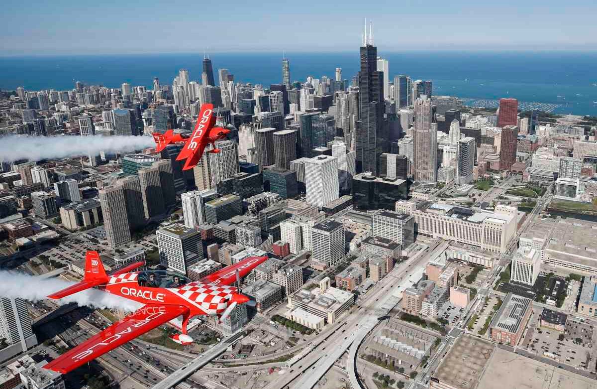 El Team Oracle, conformado por Sean D. Tucker (arriba) y Jessy Panzer (abajo) y miembros del Salón de la Fama de la Aviación, vuelan sus aeronaves sobre Chicago mientras se preparan para la 61 ° Exposición Anual del Aire y el Agua de Chicago, en Chicago, Illinois, el 15 de agosto de 2019. (Foto por KAMIL KRZACZYNSKI / AFP)