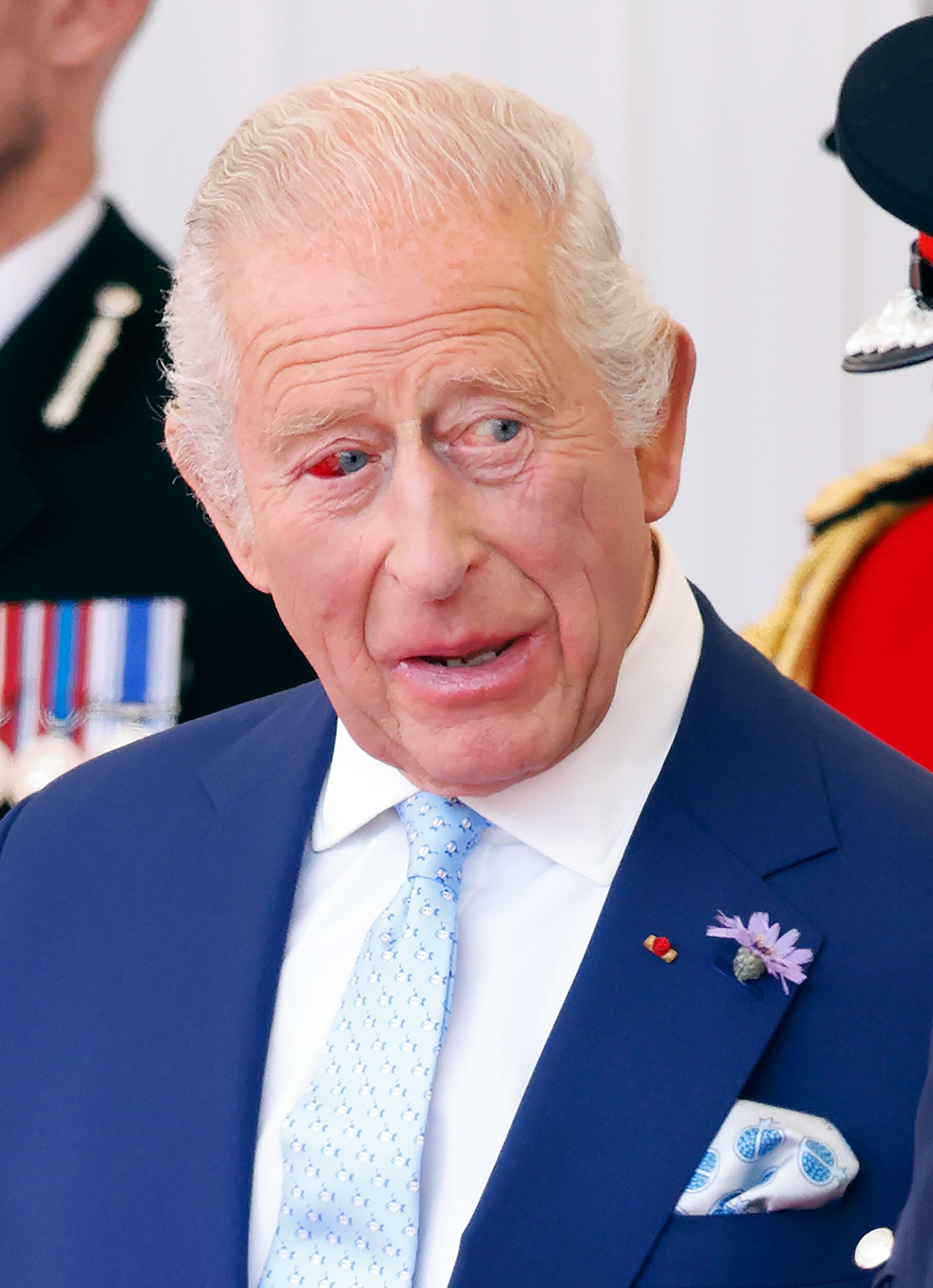 El rey Carlos III (visto con el ojo enrojecido) asiste a la bienvenida formal, en la tarima real de Datchet Road