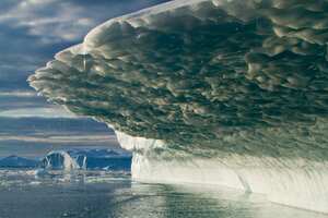 Groenlandia, Ilulissat, las luces del sol de medianoche derritiendo los icebergs paridos del glaciar Jakobshavn flotando en la bahía de Disko en la soleada tarde de verano