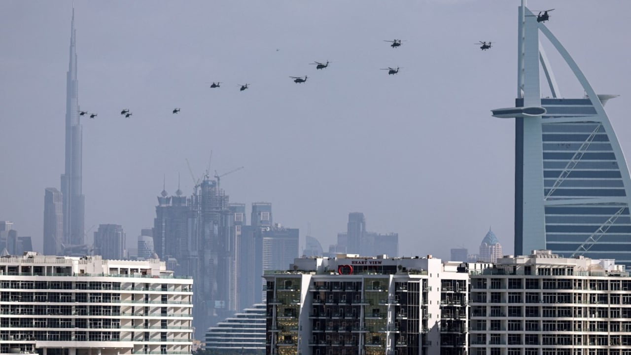 Helicópteros del ejército de los Emiratos Árabes Unidos vuelan desde el hotel Burj al Arab (R) hacia Burj Khalifa, en Dubai, el 16 de enero de 2026. (Foto de Fadel SENNA / AFP)