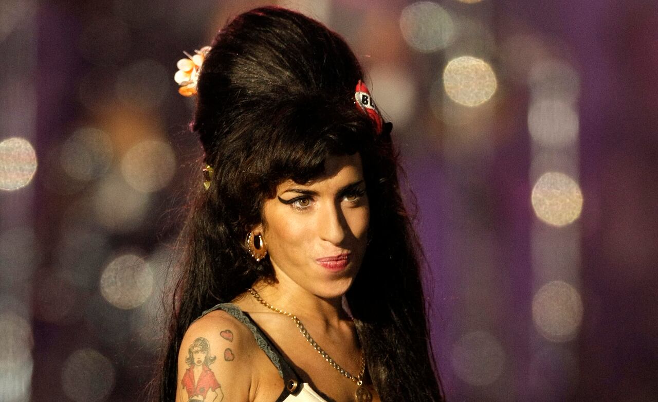 In this file photo taken on June 27, 2008 British singer Amy Winehouse performs during the 46664 concert in honour of Nelson Mandela's 90th birthday in Hyde Park, central London - Amy Winehouse may still be best known for her line: "They tried to make me go to rehab. But I said no, no, no." But 10 years after the British singer's death at 27, her family and friends say it is time to stop defining her by her well-documented struggles with addiction and destructive relationships. (Photo by SHAUN CURRY / AFP