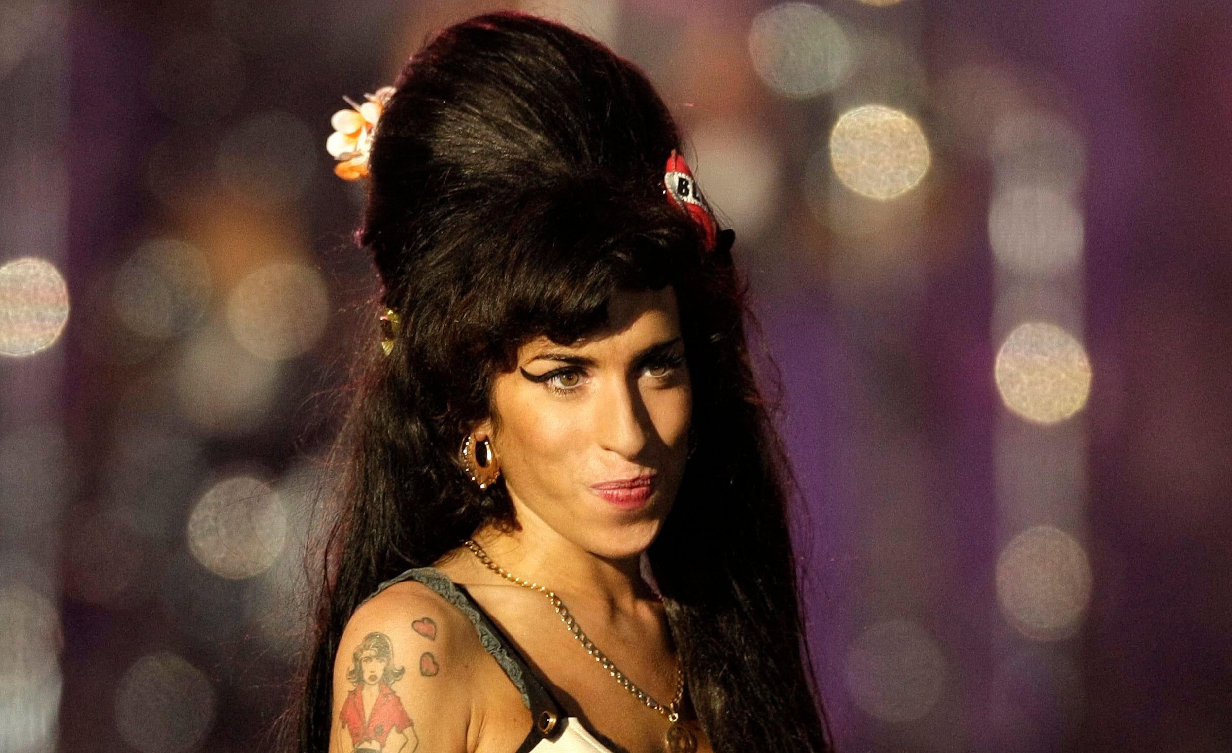 In this file photo taken on June 27, 2008 British singer Amy Winehouse performs during the 46664 concert in honour of Nelson Mandela's 90th birthday in Hyde Park, central London - Amy Winehouse may still be best known for her line: "They tried to make me go to rehab. But I said no, no, no."  But 10 years after the British singer's death at 27, her family and friends say it is time to stop defining her by her well-documented struggles with addiction and destructive relationships. (Photo by SHAUN CURRY / AFP
