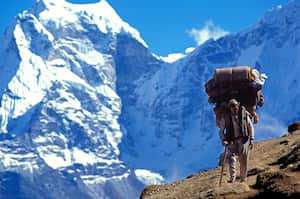 Sherpa carrying bags on an Everest trail. Nepal. (Photo by: Godong/Universal Images Group via Getty Images)
