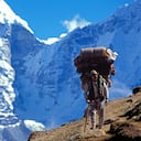 Sherpa carrying bags on an Everest trail. Nepal. (Photo by: Godong/Universal Images Group via Getty Images)
