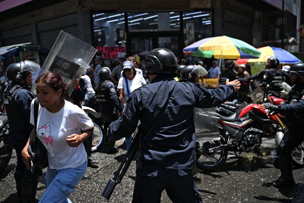 Agentes de policía se despliegan mientras opositores al gobierno de la presidenta interina venezolana Delcy Rodríguez se manifiestan en Caracas