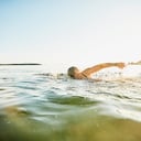 Senior woman swimming in bay on summer evening