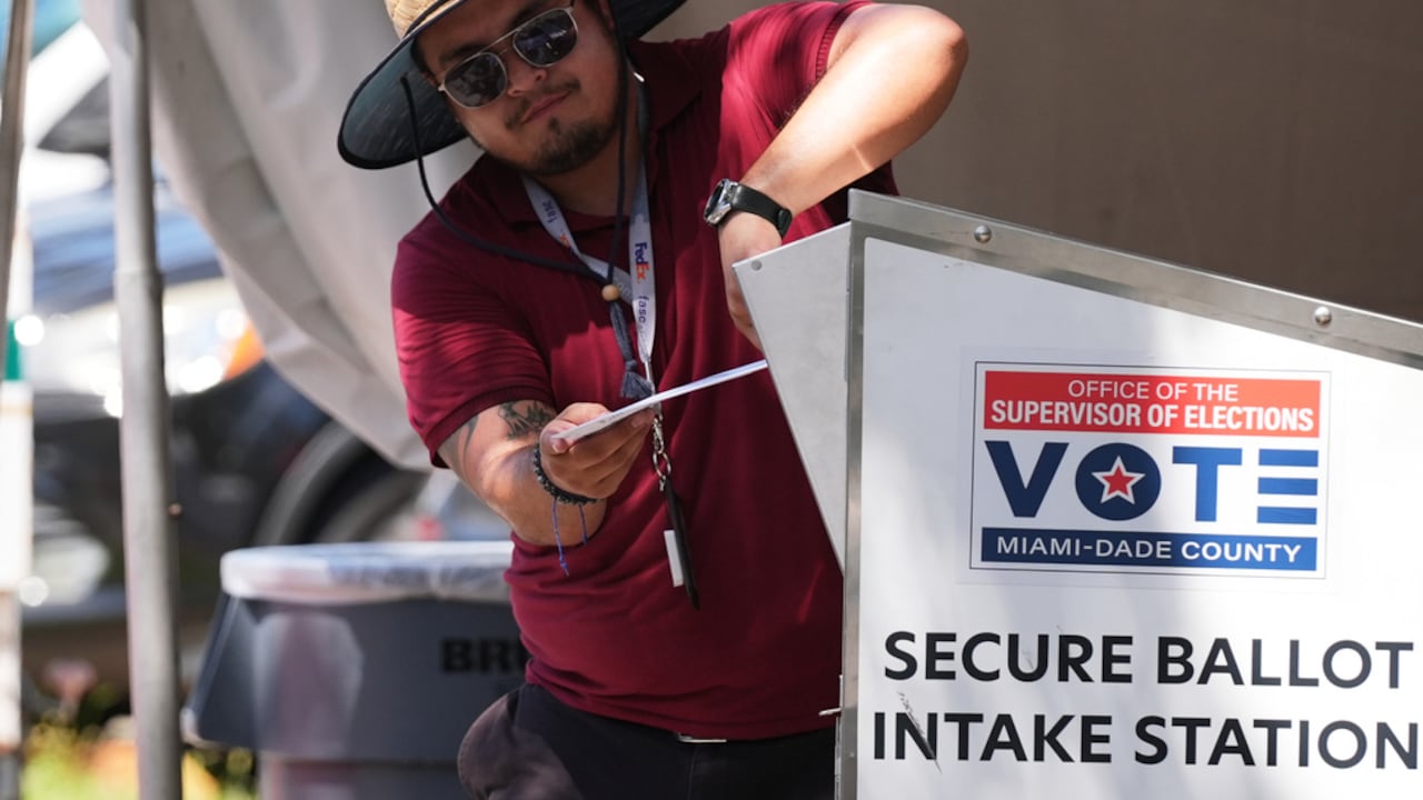 Un trabajador electoral deposita una boleta de voto por correo en un contenedor seguro en la oficina del Supervisor de Elecciones del condado de Miami-Dade, durante las elecciones primarias de Florida en Doral, Florida, el martes 18 de agosto de 2026. (Foto AP/Lynne Sladky)