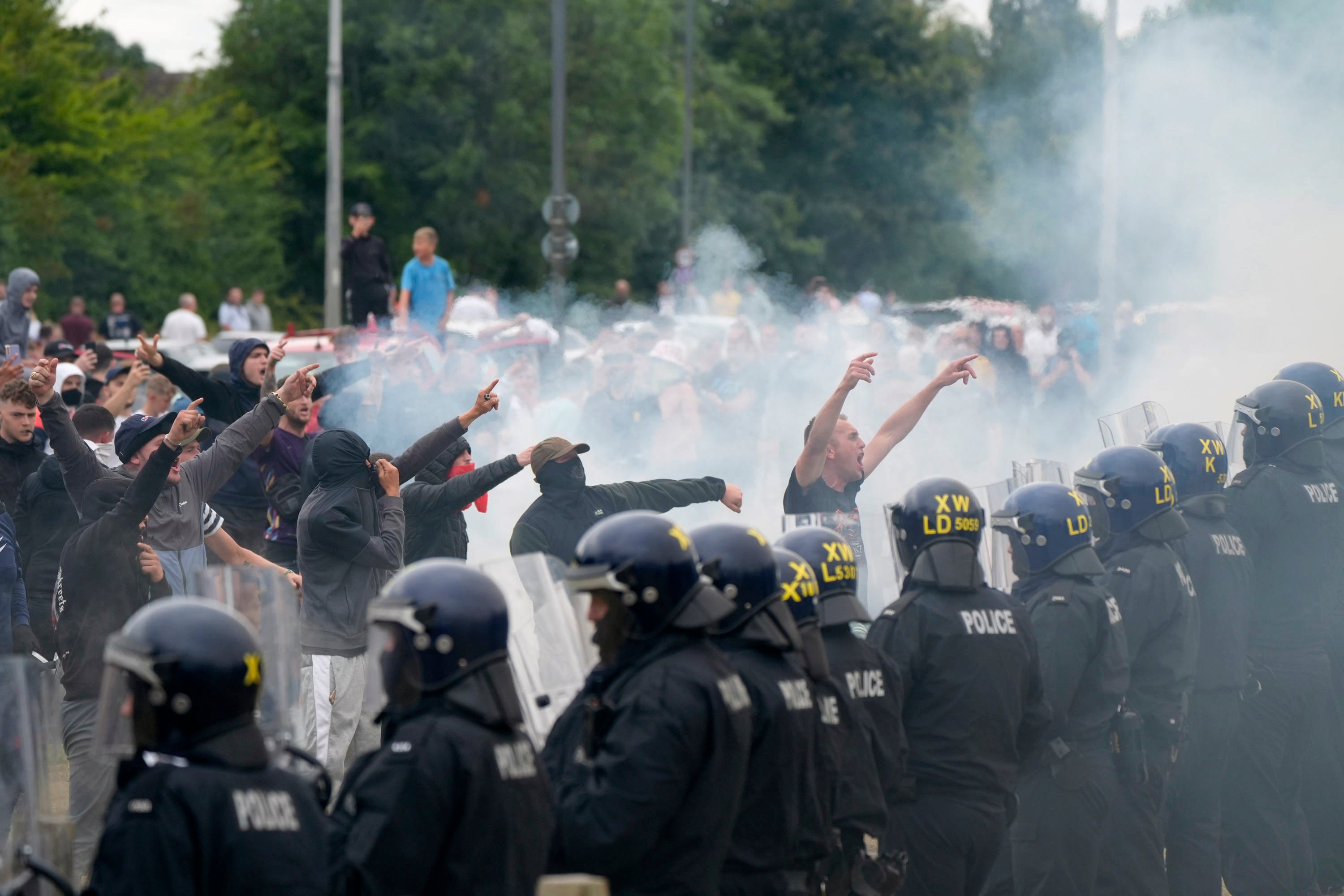 Agentes de policía se enfrentan a manifestantes durante una manifestación contra la inmigración frente al Holiday Inn Express en Rotherham, Inglaterra, el domingo 4 de agosto de 2024. (Danny Lawson/PA vía AP)