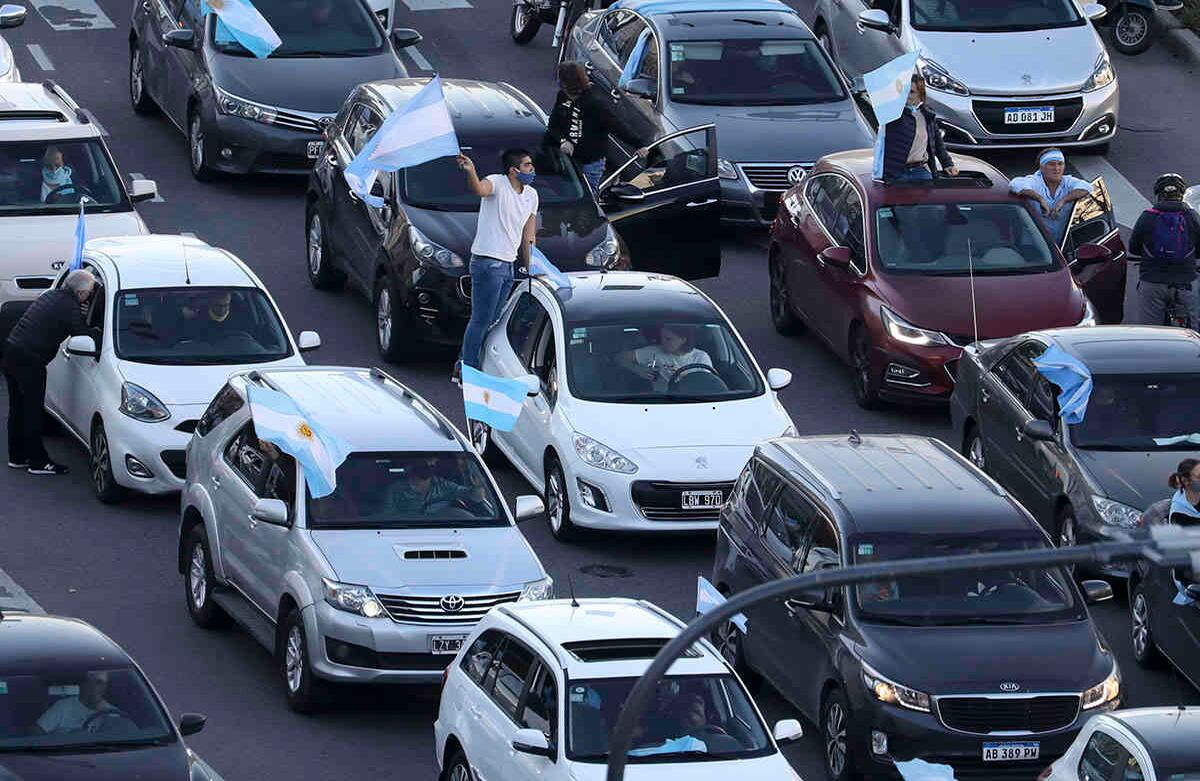 Personas conducen sus autos a lo largo de la avenida 9 de Julio ondeando banderas para protestar por las políticas de cuarentena del gobierno argentino para contener el coronavirus. Buenos Aires, Argentina, el lunes 17 de agosto de 2020. Foto: Natacha Pisarenko / AP