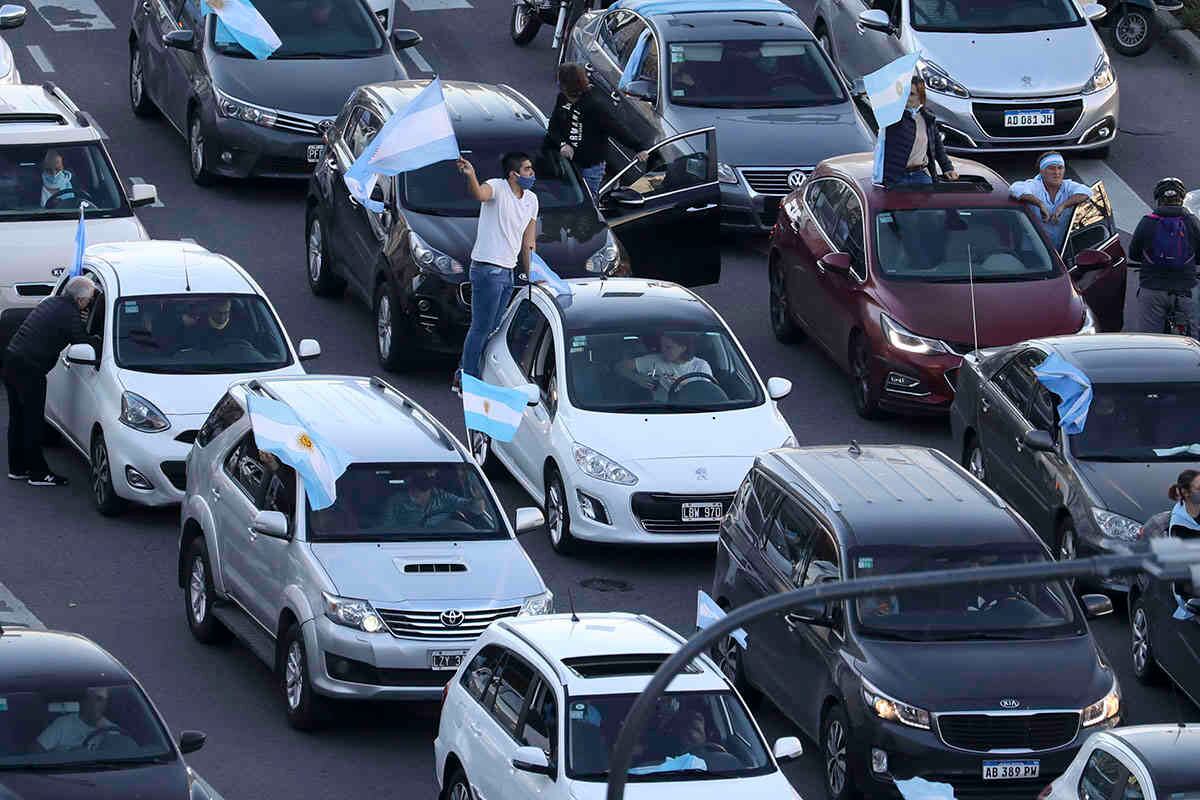Personas conducen sus autos a lo largo de la avenida 9 de Julio ondeando banderas para protestar por las políticas de cuarentena del gobierno argentino para contener el coronavirus. Buenos Aires, Argentina, el lunes 17 de agosto de 2020. Foto: Natacha Pisarenko / AP