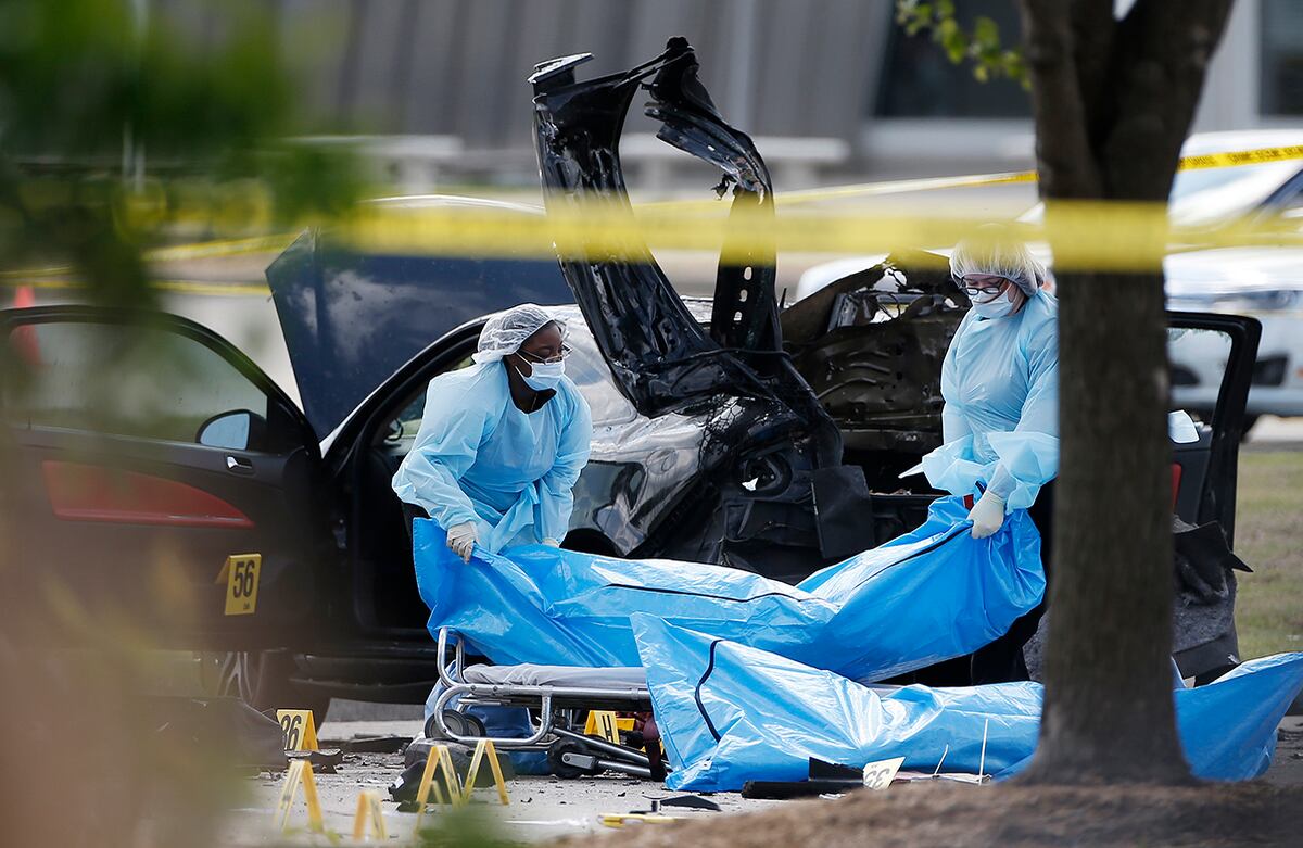 El personal recoge los cuerpos de los asesinos que irrumpieron en la sede de concurso de caricaturas del profeta Mahoma el domingo por la noche en Garland, Texas. (AP/Brandon Wade)