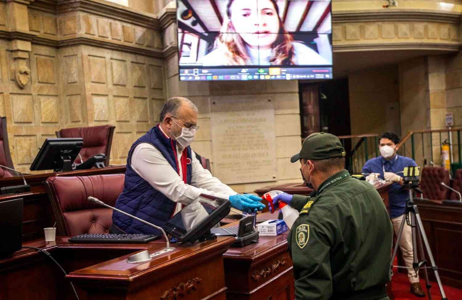 Un policía le aplica desinfectante al senador Roy Barreras.  Foto: Juan Carlos Sierra / SEMANA