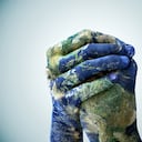 Una foto recortada de manos pintadas para parecerse a la tierra