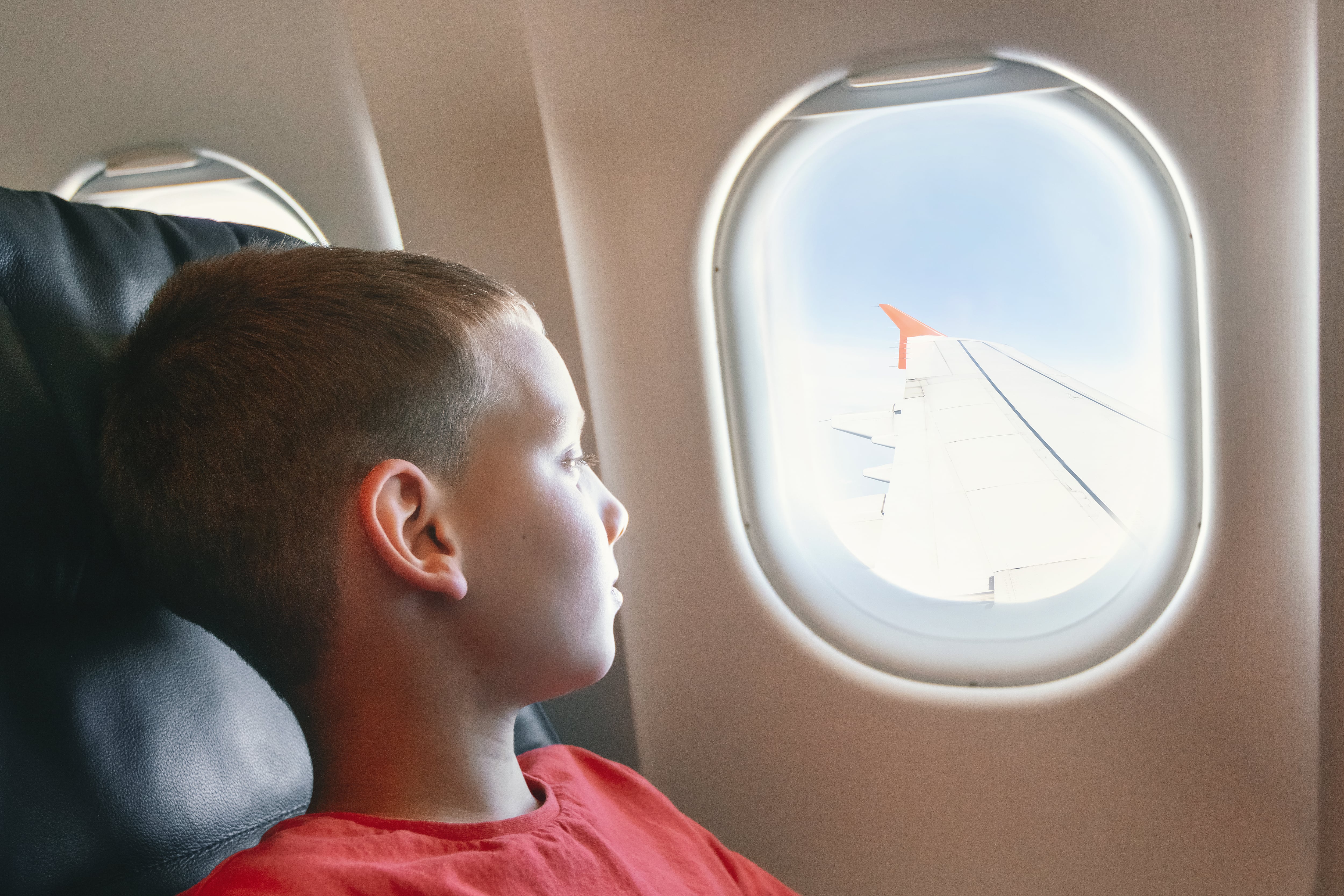 Niño ubicado en el asiento diagonal al ala del avión.