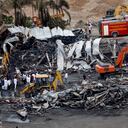 Los funcionarios limpian restos carbonizados en el lugar de un accidente de incendio al día siguiente del desastre, en un parque de diversiones en Rajkot, en el estado indio de Gujarat, el 26 de mayo de 2024.