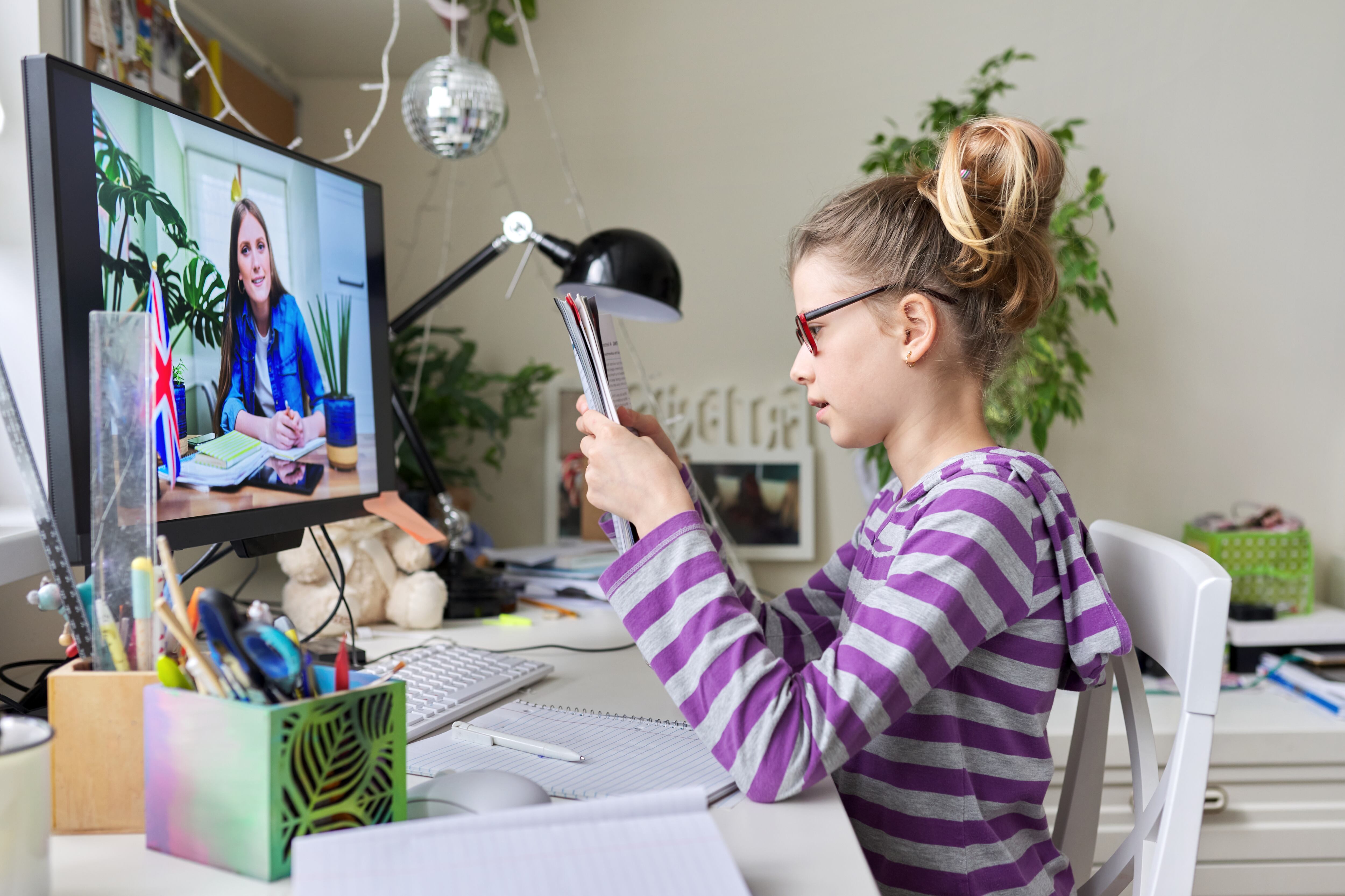 Aprender el concepto de inglés. Niña en casa estudiando idioma en casa, lección en línea, aprendizaje a distancia, e-educación. Niña estudiante hablando con el profesor escribiendo y leyendo