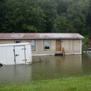 Las inundaciones suben en Bridgewater, Vt., el lunes 10 de julio de 2023, sumergiendo vehículos estacionados y amenazando casas cerca del río Ottauquechee.