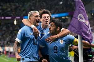 Giorgian de Arrascaeta, de Uruguay, a la izquierda, celebra con su compañero Luis Suárez el gol inicial contra Ghana durante un partido de fútbol del grupo H de la Copa Mundial en el estadio Al Janoub en Al Wakrah, Qatar, el viernes 2 de diciembre de 2022.