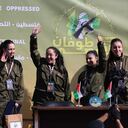 Four Israeli hostages, (L-R) Naama Levy, Liri Albag, Daniella Gilboa and Karina Ariev, wave from a stage before Hamas fighters hand them over to a team from the Red Cross in Gaza City on January 25, 2025. Four freed Israeli women hostages were home in Israel January 25, ending more than 15 months of captivity after Hamas militants handed them over to the Red Cross under a truce deal in the Gaza war. (Photo by Omar AL-QATTAA / AFP)