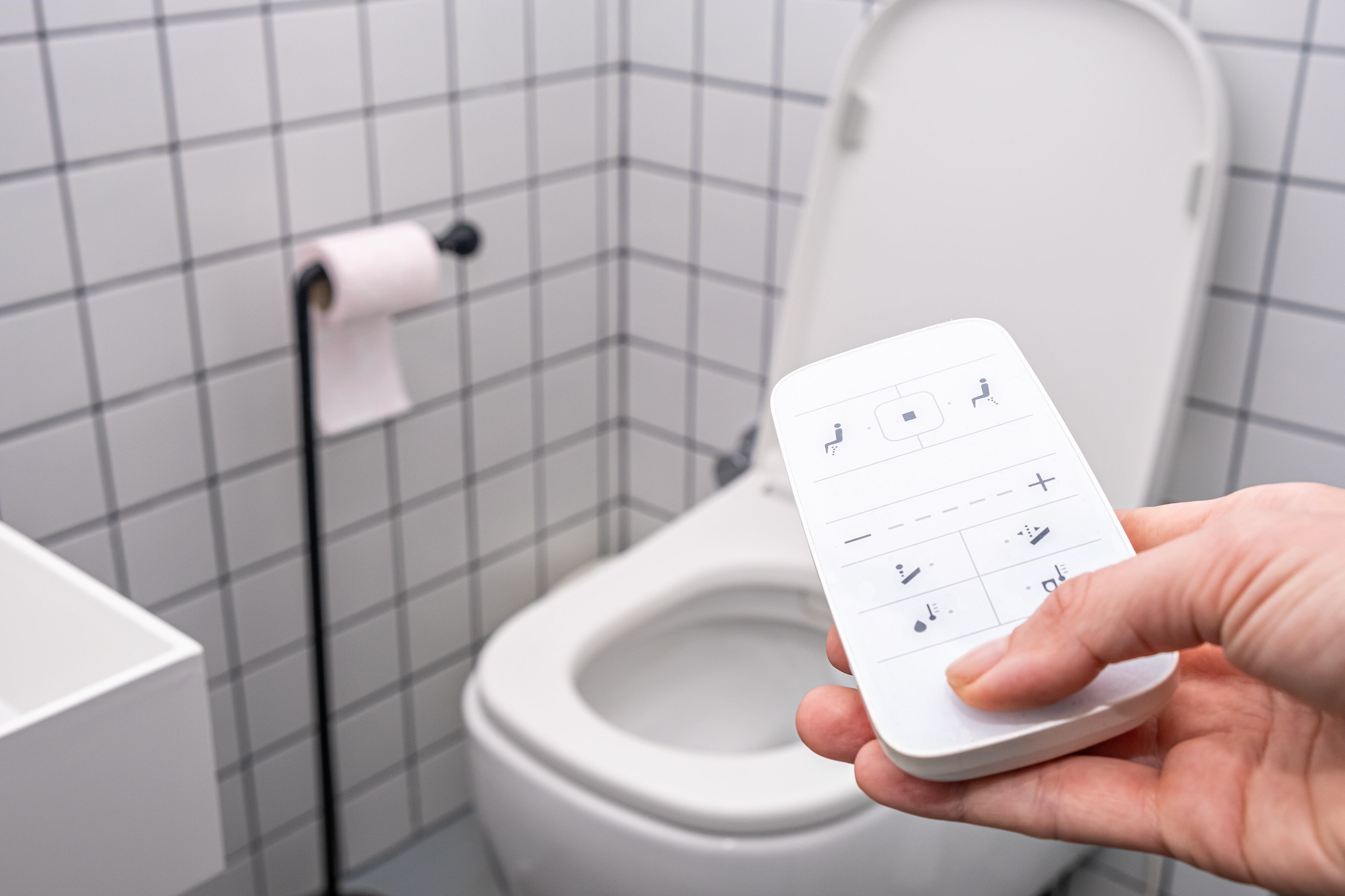 remote Control with buttons of the smart toilet bowl. high technology automatic modern flush toilet.