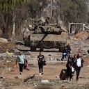 Palestinos que huyen del norte por la carretera de Salaheddine pasan junto a un tanque del ejército israelí en el distrito de Zeitoun, en las afueras del sur de la ciudad de Gaza, el 24 de noviembre de 2023, tras un alto el fuego de cuatro días que comenzó a primera hora de la mañana.