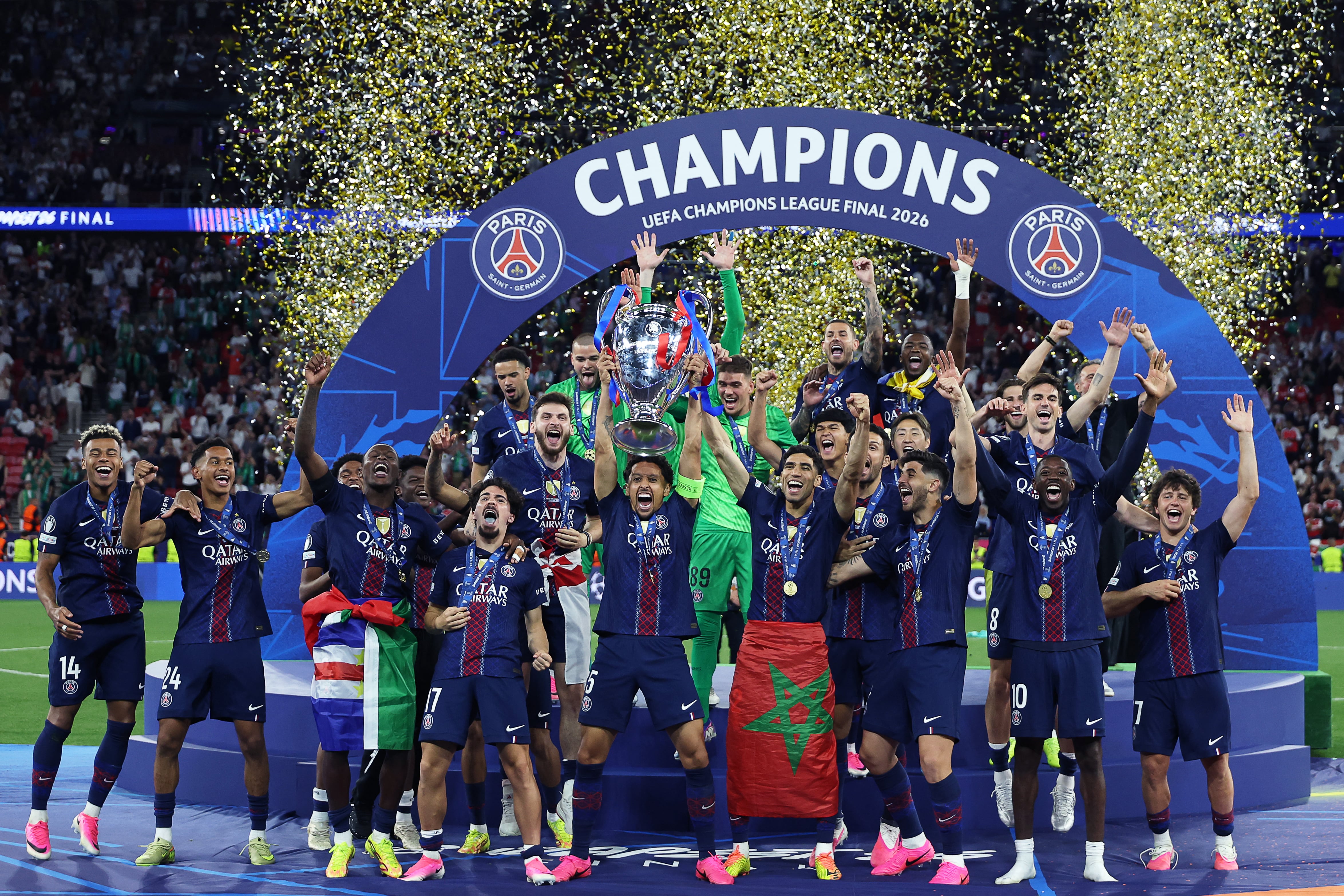 El defensa brasileño del Paris Saint-Germain, Marquinhos (C), número 05, levanta el trofeo mientras celebra con sus compañeros la victoria en la final de la Liga de Campeones de la UEFA entre el Paris Saint-Germain (PSG) y el Arsenal FC en el Puskás Arena de Budapest el 30 de mayo de 2026. (Foto de FRANCK FIFE / AFP)