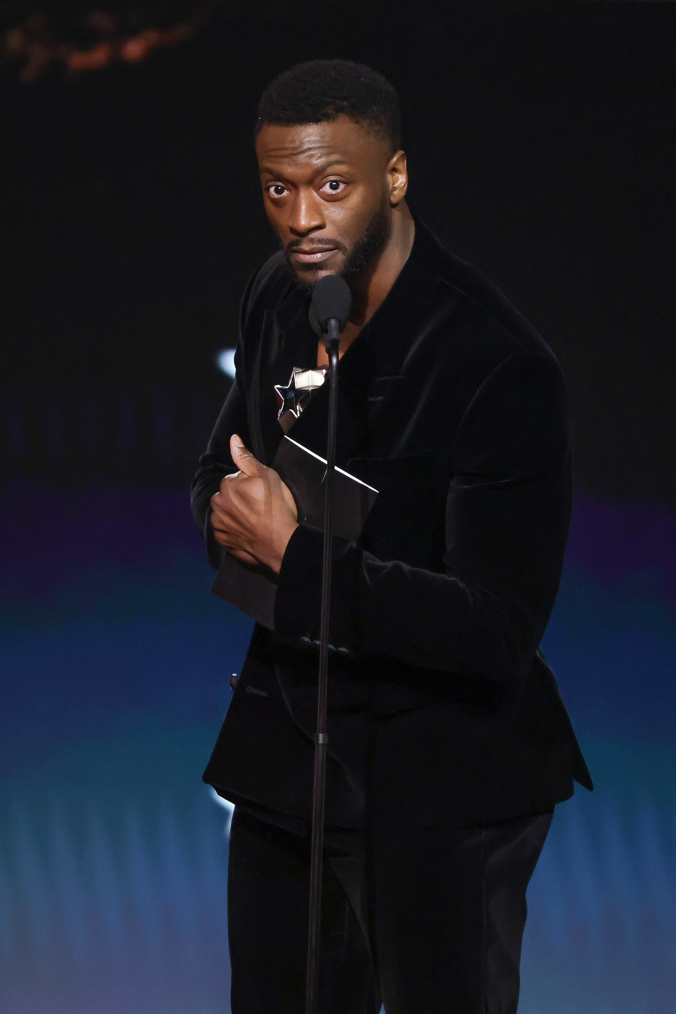 Aldis Hodge, en nombre de Tadanobu Asano, recibe el premio al Mejor Actor de Reparto en una Serie Dramática en el escenario durante la 30ª entrega anual de los Premios Critics Choice en Barker Hangar.