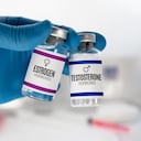 Hand of doctor with two injection vials for treatment with Testosterone and Estrogen hormones. Doctor With bottles for Testosterone and Estrogen hormonal balance therapy