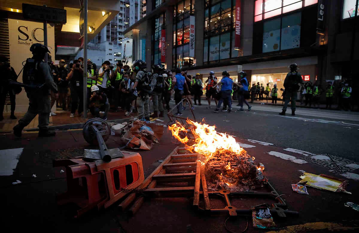 Manifestantes contra la nueva ley de seguridad inician un incendio para bloquear el tráfico durante la marcha por el aniversario de la entrega de Hong Kong desde Gran Bretaña a China. Foto: Vincent Yu/AP